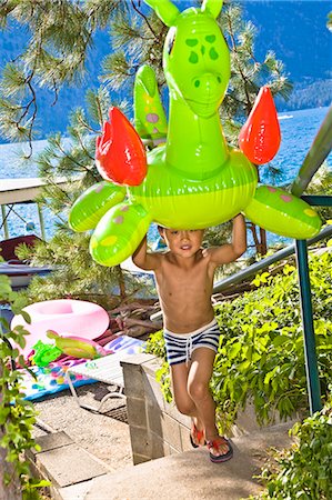 stair sports - boy carrying dragon floatie up from lake Stock Photo - Premium Royalty-Free, Code: 673-03405743