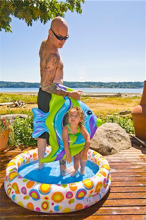 female floatation device - man and girl in wading pool near beach Stock Photo - Premium Royalty-Free, Code: 673-03405757