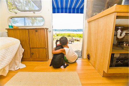 Boy and dog sitting in camper doorway Foto de stock - Sin royalties Premium, Código: 673-03405768