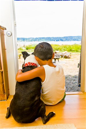 Boy and dog sitting in camper doorway Stock Photo - Premium Royalty-Free, Code: 673-03405769