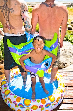 portrait tattoos for men - tattoed men and boy in wading pool at beach Foto de stock - Sin royalties Premium, Código: 673-03405761