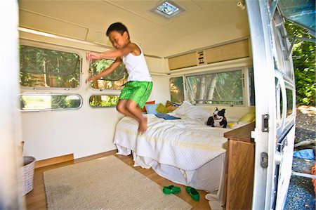 people jumping into bed - Boy and dog on bed in camper Stock Photo - Premium Royalty-Free, Code: 673-03405775