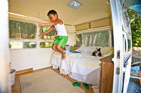 Boy and dog on bed in camper Stock Photo - Premium Royalty-Free, Code: 673-03405775