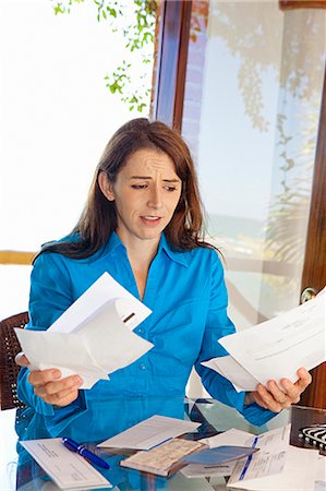 paying bills - woman paying bills at dining room table Stock Photo - Premium Royalty-Free, Code: 673-03623168