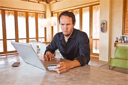 e-commerce - man working on laptop at home Stock Photo - Premium Royalty-Free, Code: 673-03623265