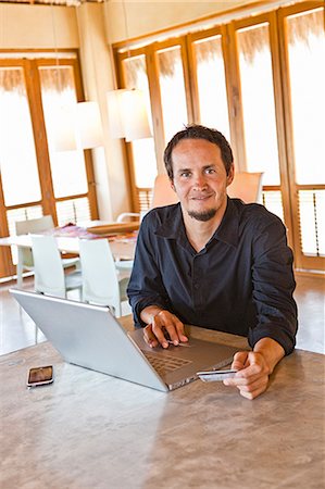 payment credit card counter - man working on laptop at home Stock Photo - Premium Royalty-Free, Code: 673-03623267