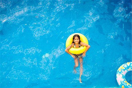 floating in a pool - girl in yellow life ring in pool Stock Photo - Premium Royalty-Free, Code: 673-03826282