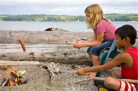 smoking food - children roasting hotdogs over beach fire Stock Photo - Premium Royalty-Free, Code: 673-03826299