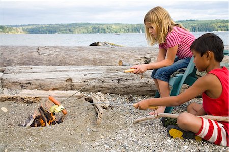 smoking food - children roasting hotdogs over beach fire Stock Photo - Premium Royalty-Free, Code: 673-03826300