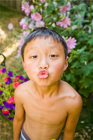 ridiculous - asian boy with puckered lips outdoors Stock Photo - Premium Royalty-Free, Code: 673-03826322