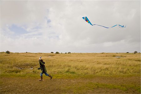 boy running with kite in air Foto de stock - Sin royalties Premium, Código: 673-03826377