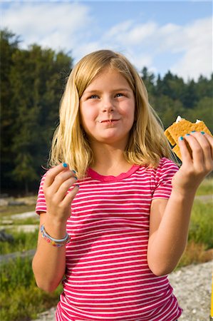 photo preteen dessert - girl eating s'more outdoors Foto de stock - Sin royalties Premium, Código: 673-03826562