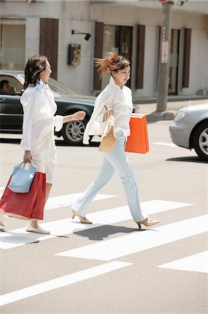 Two young women crossing road Stock Photo - Premium Royalty-Free, Code: 685-02937099