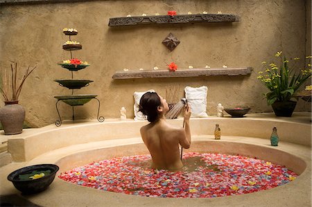 Young woman taking bath with flower petals Stock Photo - Premium Royalty-Free, Code: 685-02937229