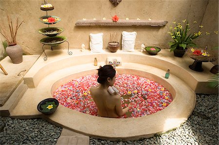 Young woman taking bath with flower petals Stock Photo - Premium Royalty-Free, Code: 685-02937230