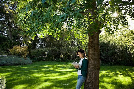 Young woman reading under a tree Foto de stock - Sin royalties Premium, Código: 685-02937767