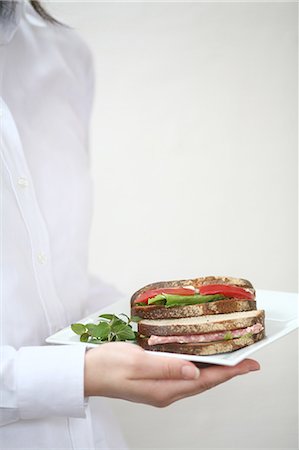 A young woman carrying sandwiches on plate Foto de stock - Sin royalties Premium, Código: 685-02938090