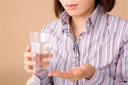 simsearch:685-02938515,k - A woman holding glass of water and pills Foto de stock - Royalty Free Premium, Número: 685-02938527