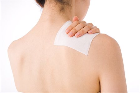 simsearch:685-02938515,k - A woman putting poultice on her shoulder Stock Photo - Premium Royalty-Free, Code: 685-02938568