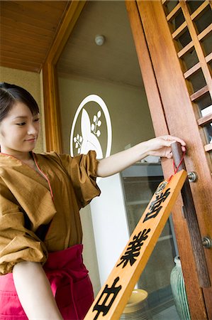 simsearch:685-02938871,k - Young woman placing open sign at Japanese restaurant Foto de stock - Sin royalties Premium, Código: 685-02938846