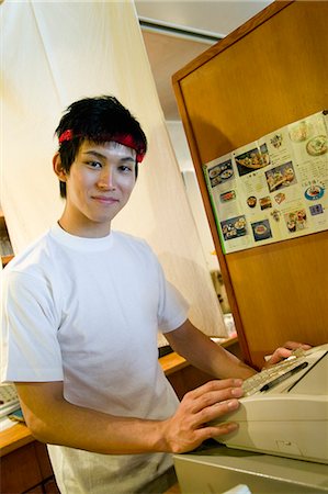 restaurant register - Young man working on cash register Stock Photo - Premium Royalty-Free, Code: 685-02938851