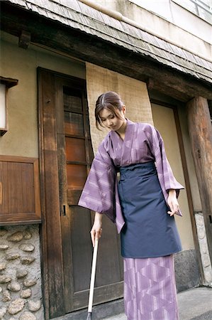 Young woman cleaning with broom Stock Photo - Premium Royalty-Free, Code: 685-02938887