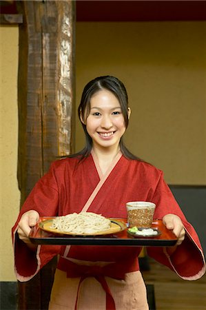 Young woman carrying a tray of noodles Stock Photo - Premium Royalty-Free, Code: 685-02938900