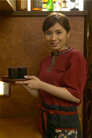 Waitress carrying a tray of tea Stock Photo - Premium Royalty-Free, Code: 685-02938903