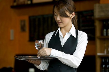 Waitress holding tray with glasses of water Stock Photo - Premium Royalty-Free, Code: 685-02938964