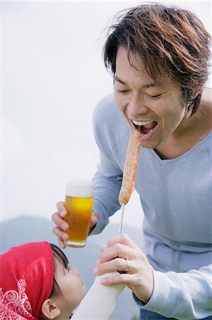 sausage eating - Father and daughter having barbeque Stock Photo - Premium Royalty-Free, Code: 685-02939077