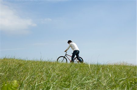 simsearch:685-02939247,k - Young man pushing bicycle Foto de stock - Royalty Free Premium, Número: 685-02939239