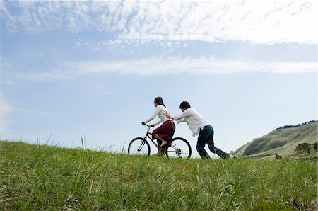 simsearch:685-02939244,k - Young man pushing young woman on bicycle Stock Photo - Premium Royalty-Free, Code: 685-02939269