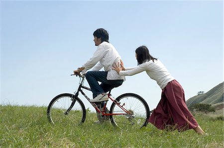 simsearch:685-02939247,k - Young woman pushing young man on bicycle Foto de stock - Royalty Free Premium, Número: 685-02939270