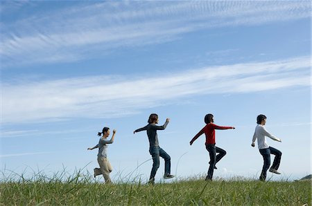 simsearch:685-02939244,k - Four young people skipping in field Stock Photo - Premium Royalty-Free, Code: 685-02939301