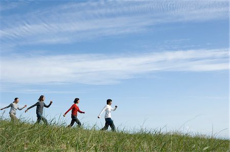simsearch:685-02939247,k - Four young people skipping in field Foto de stock - Royalty Free Premium, Número: 685-02939302