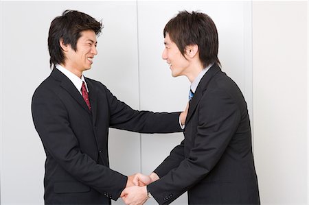 Two young businessmen shaking hands Stock Photo - Premium Royalty-Free, Code: 685-02939694
