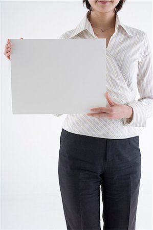 Businesswoman holding blank placard Stock Photo - Premium Royalty-Free, Code: 685-02940128