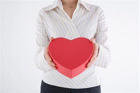 simsearch:685-02940140,k - Businesswoman holding heart-shaped box Stock Photo - Premium Royalty-Free, Code: 685-02940142