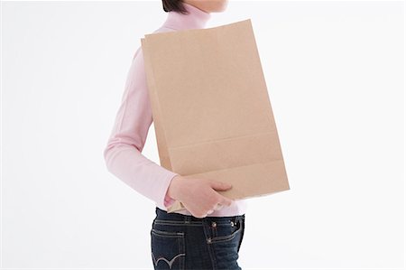 simsearch:685-02940184,k - Woman holding paper bag Foto de stock - Sin royalties Premium, Código: 685-02940151