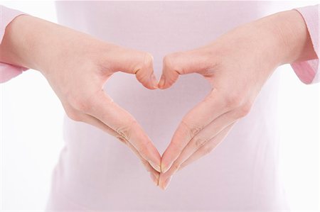 simsearch:685-02940140,k - Woman making heart shape with her hands Stock Photo - Premium Royalty-Free, Code: 685-02940181