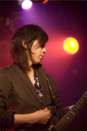 Young man playing electric guitar on stage Stock Photo - Premium Royalty-Free, Code: 685-02940337