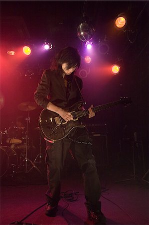 simsearch:685-02940330,k - Young man playing electric guitar on stage Fotografie stock - Premium Royalty-Free, Codice: 685-02940346