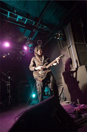 simsearch:685-02940330,k - Young man playing electric guitar on stage Fotografie stock - Premium Royalty-Free, Codice: 685-02940342