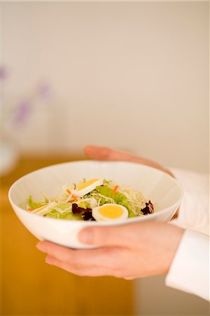 simsearch:685-02940844,k - Young woman holding bowl of salad Fotografie stock - Premium Royalty-Free, Codice: 685-02940404