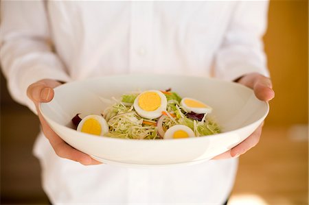simsearch:685-02940844,k - Young woman holding bowl of salad Fotografie stock - Premium Royalty-Free, Codice: 685-02940403