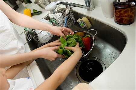Woman and girl washing vegetables Stock Photo - Premium Royalty-Free, Code: 685-02940655