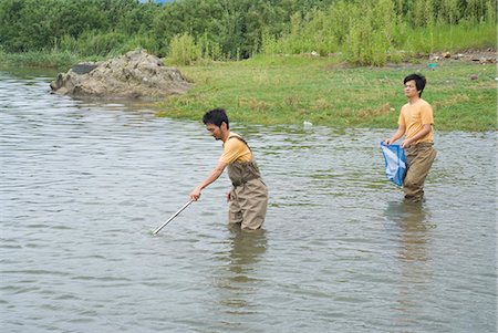 Two people cleaning river Stock Photo - Premium Royalty-Free, Code: 685-02941319