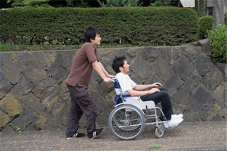 disabled asian people - Young man pushing man on wheelchair Stock Photo - Premium Royalty-Free, Code: 685-02941343