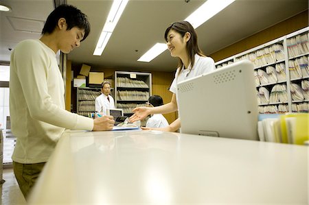 simsearch:685-02941550,k - Nurse talking with patient at reception Stock Photo - Premium Royalty-Free, Code: 685-02941575