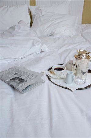 pillows in hotel room - Newspaper and cup of coffee on bed Stock Photo - Premium Royalty-Free, Code: 685-02941629